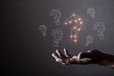 human hand holding bright question marks; Shutterstock ID 1050323603